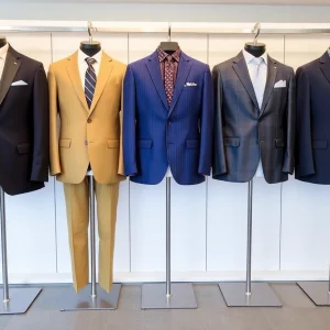 Modern tailored suits displayed in a vibrant retail setting.